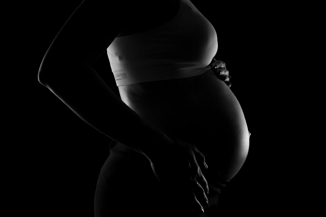 a black and white photo of a pregnant woman
