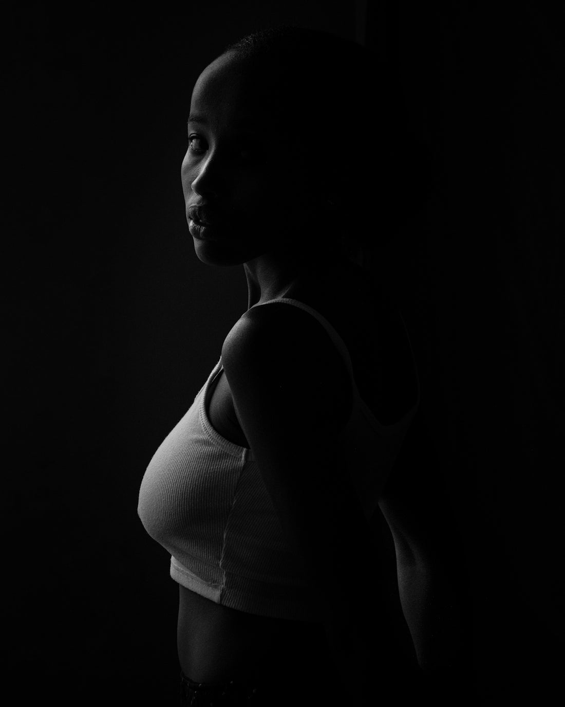 a black and white photo of a woman in a tank top