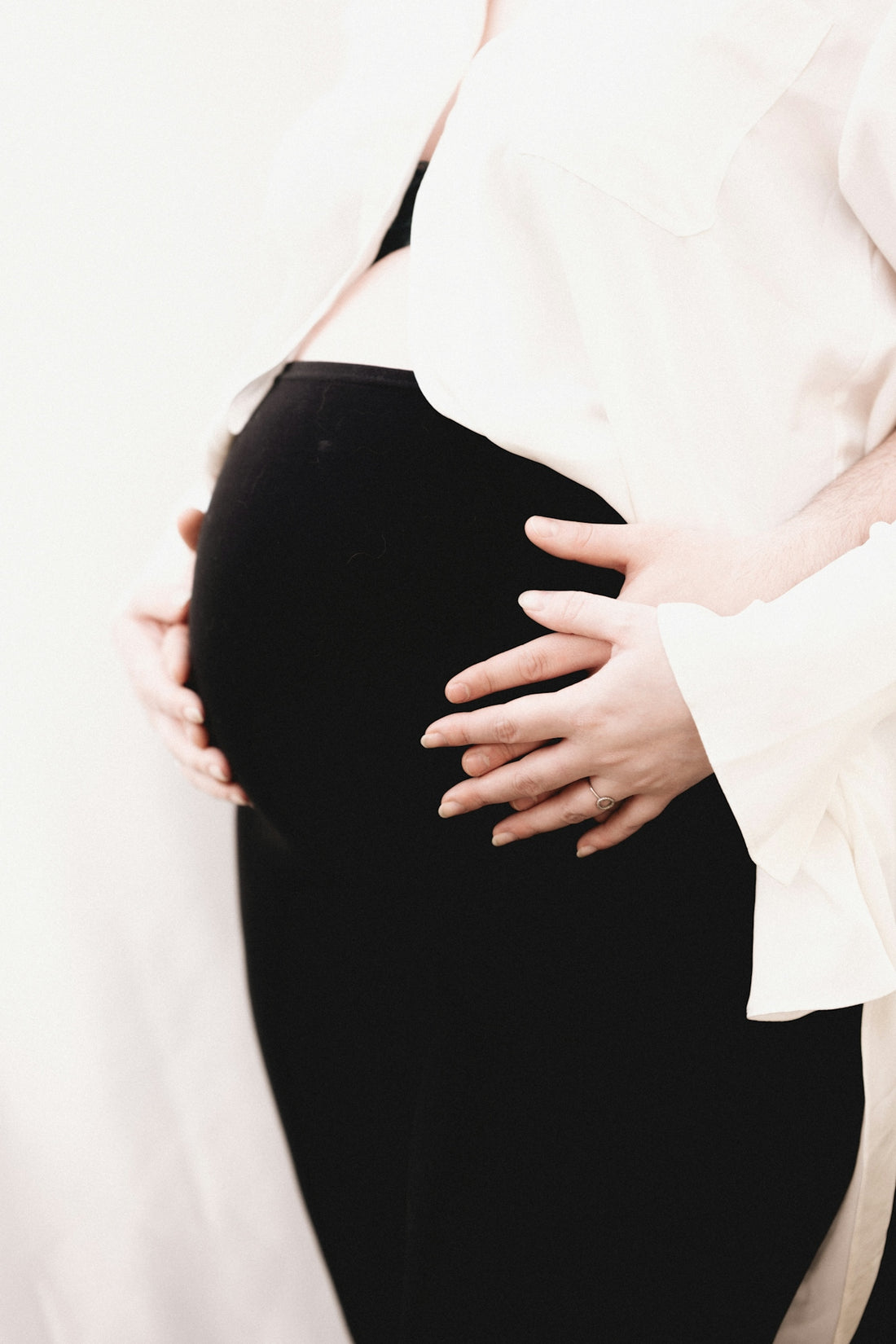 a pregnant woman in a white shirt and black pants