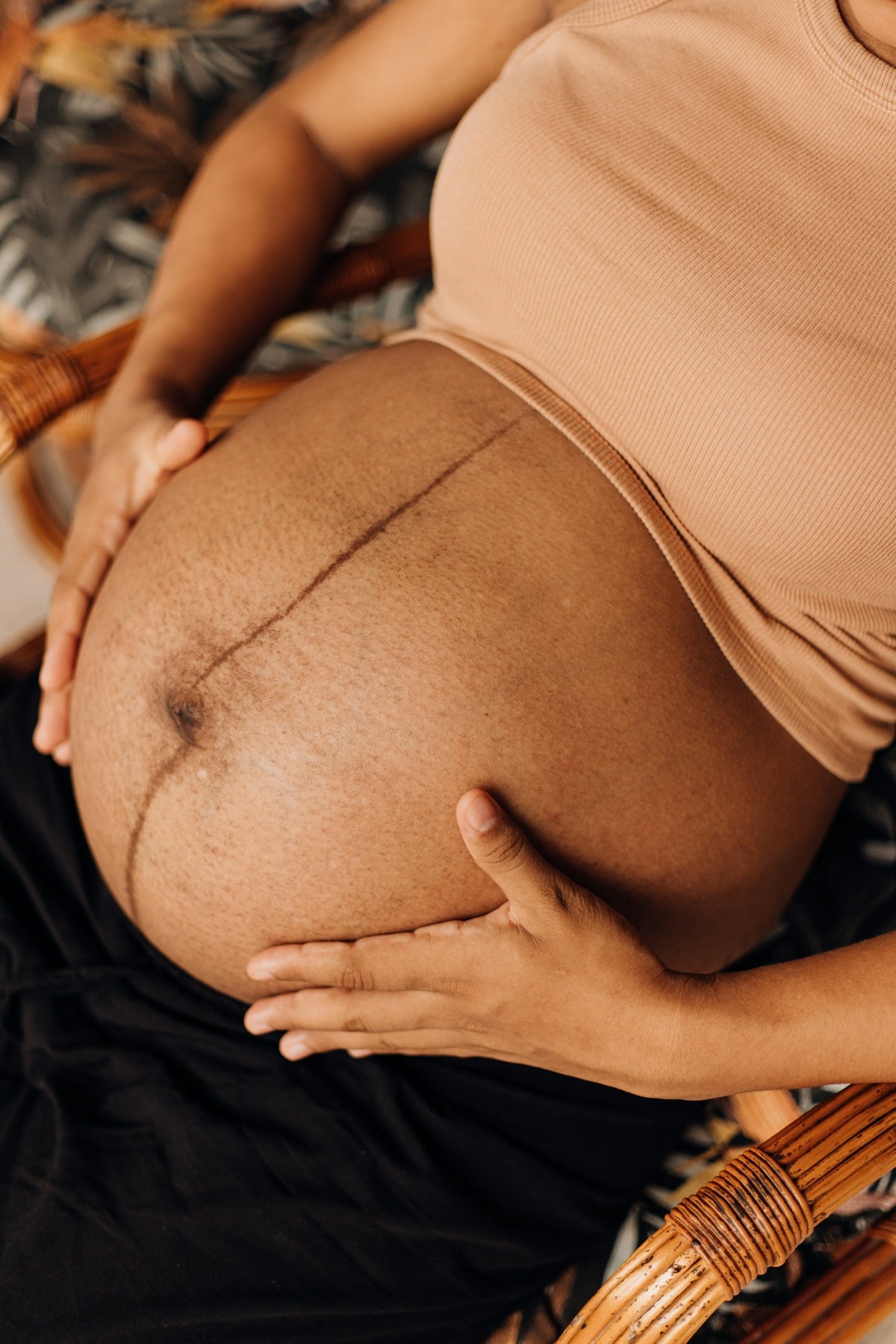 a pregnant woman sitting in a chair holding her belly
